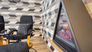 Un interior moderno con chimenea, azulejos con diseño y asientos de cuero.