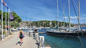 En lysthavn med flere sejlbåde i havnen, en sti for fodgængere og flag.