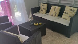 Una sala de estar con un sofá color café oscuro, una mesita de centro y una pequeña maqueta de un velero.