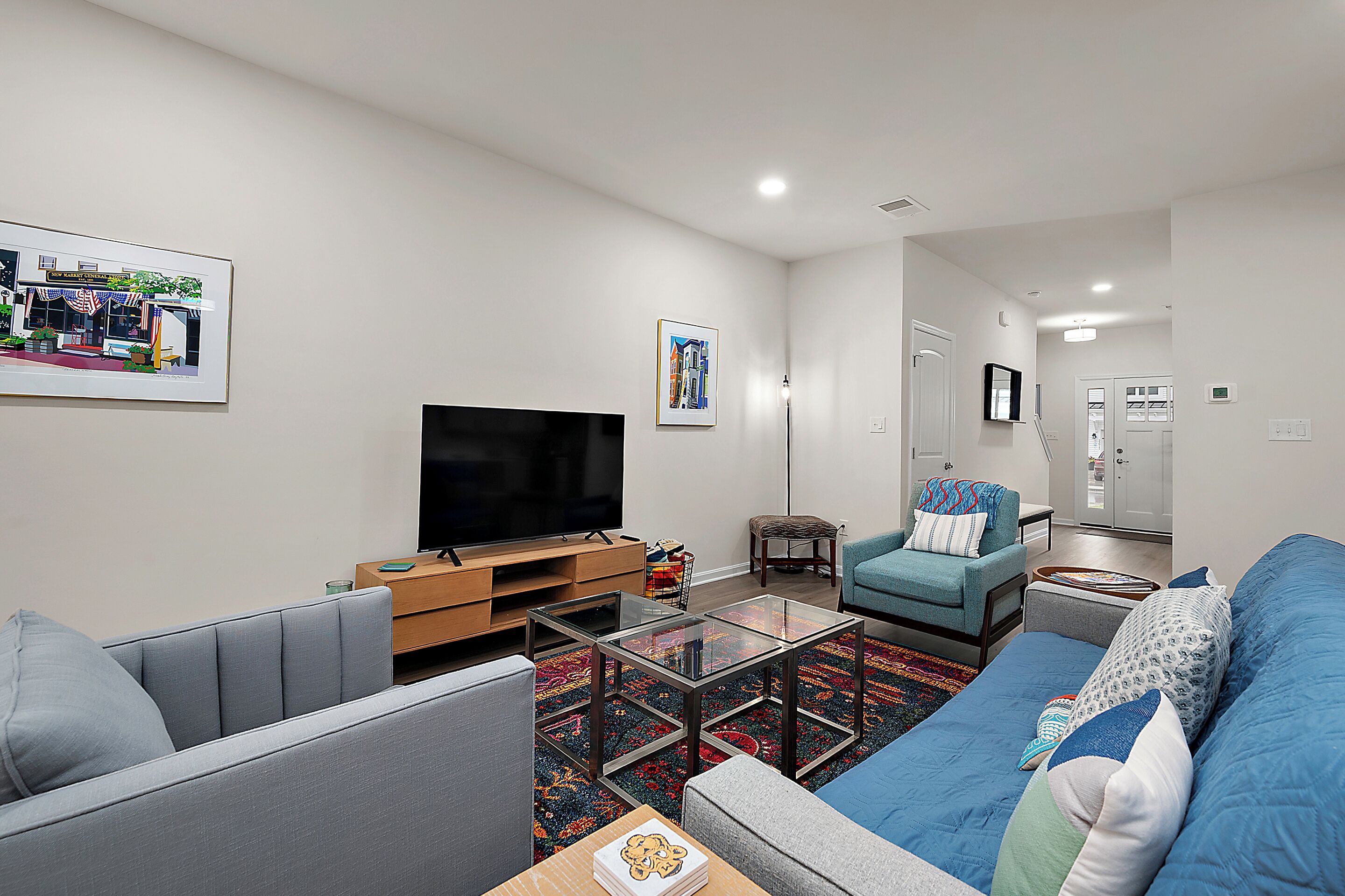 A modern living room with a flat-screen TV, a sofa, a chair, and a coffee table.