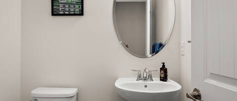 Ein Badezimmer mit Toilette, Waschbecken und Spiegel.