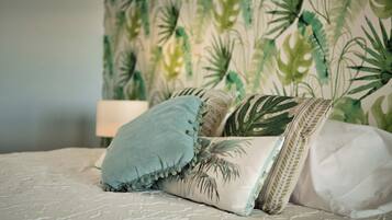 A bed with a patterned bedspread and decorative pillows.