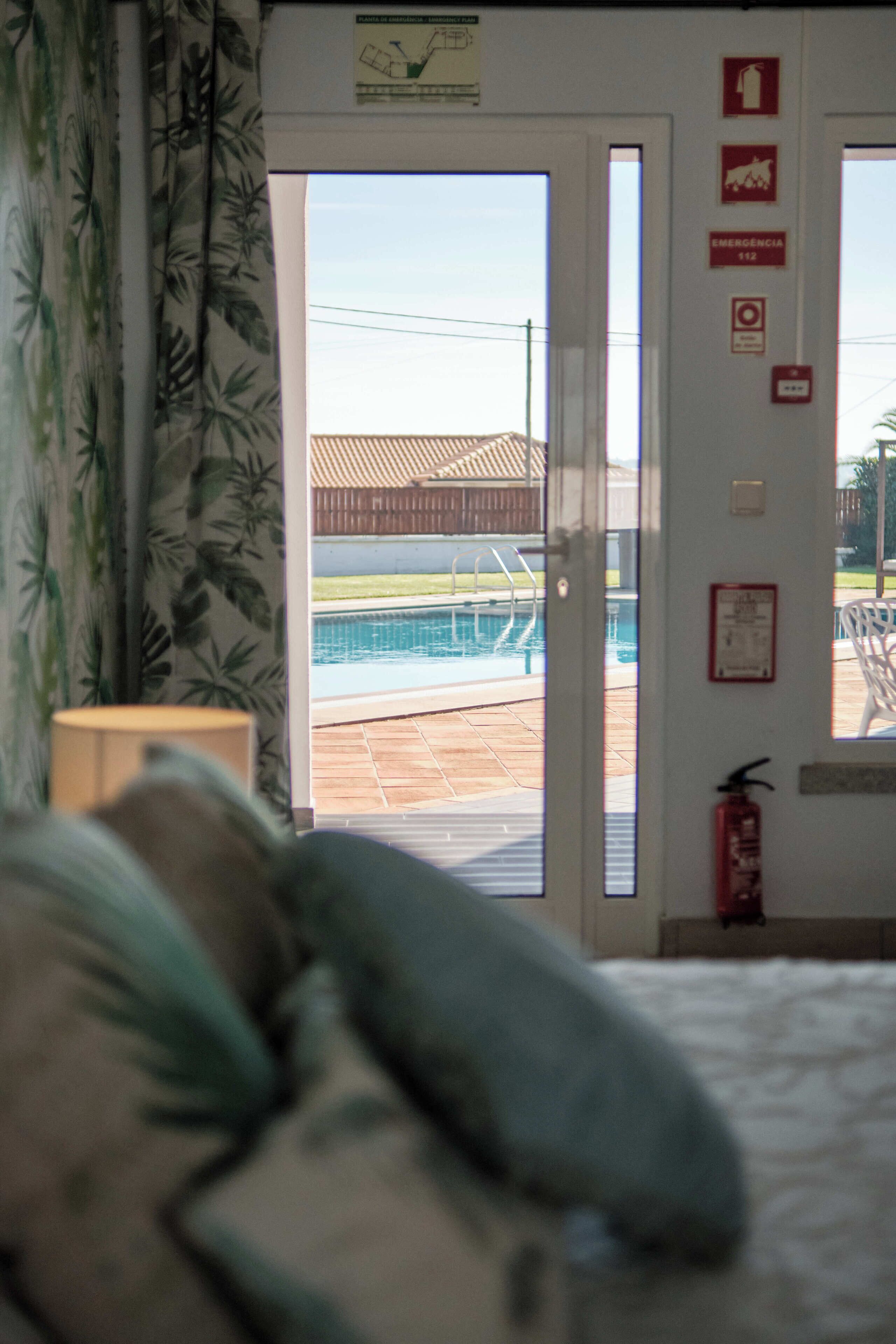 Ein Zimmer mit Blick auf einen Swimmingpool, einem Feuerlöscher und Notausgangsschildern.