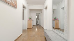 Un pasillo con un banco, un armario de madera y un espejo.