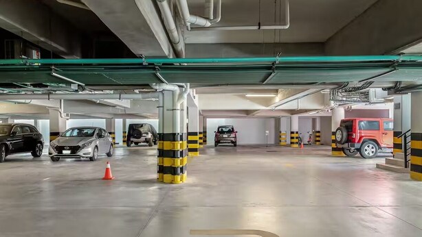 Un estacionamiento con varios niveles, con coches aparcados en cada uno.