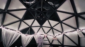 A geodesic dome structure with a central air conditioning unit, string lights, and a welcome sign. - Slate Serenity/Pet Friendly/Private Hot Tub (South Haven)