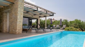 A swimming pool with lounge chairs and a covered seating area. - Pet friendly home in Novigrad (Novigrad)