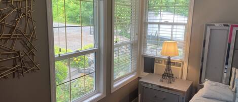 A bedroom with a bed, bedside table, lamp, and a radiator.