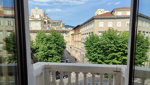 A balcony with a view of a street lined with buildings and trees. - Colori di Trieste - TriesteCenter (Trieste)