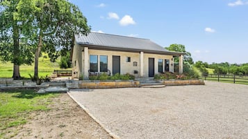 A two-story building with a gravel driveway and a fenced area.