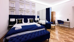 A hotel room with a large bed, a desk, and a mirror. - Wiślna Main Square Apartments Self Check-in (Kraków)