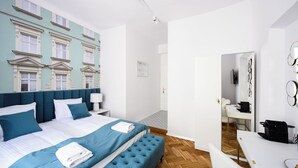 A modern hotel room with a large bed, a desk, and a mirror. - Wiślna Main Square Apartments Self Check-in (Kraków)
