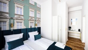 Una camera d'albergo con un letto grande, una scrivania e un armadio.