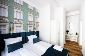 Hotellihuone, jossa on suuri sänky, työpöytä ja vaatekaappi.