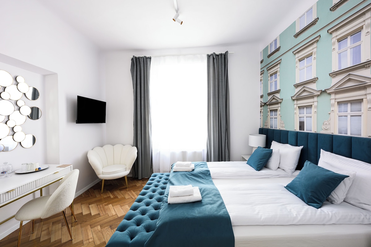 Habitación de hotel con una cama grande, un escritorio, una silla y un televisor.