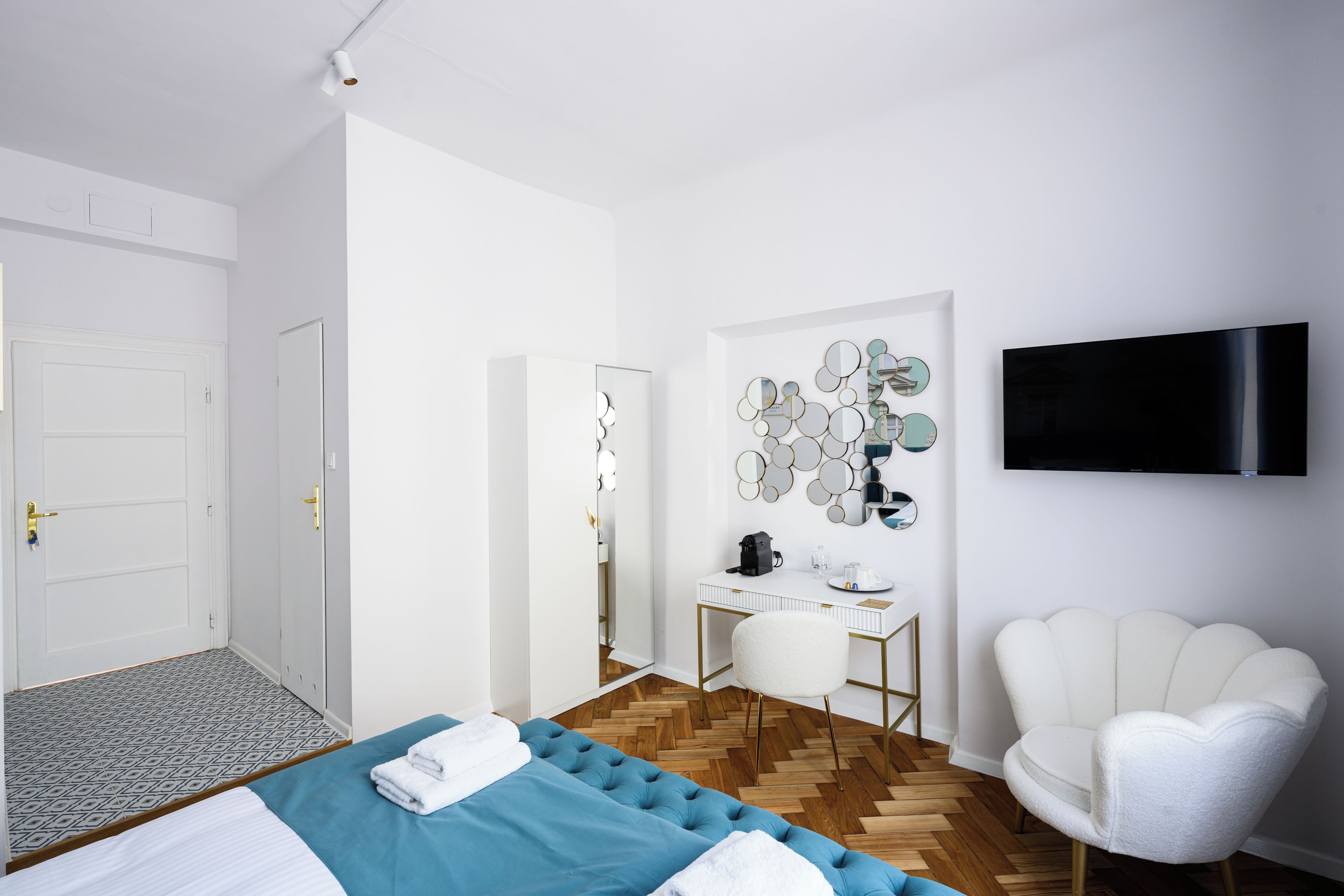 Una camera d'albergo moderna con un letto, una scrivania, una sedia e una televisione.