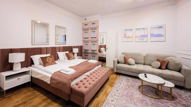 Una camera d'albergo con un letto grande, un divano, un tavolino e uno specchio.