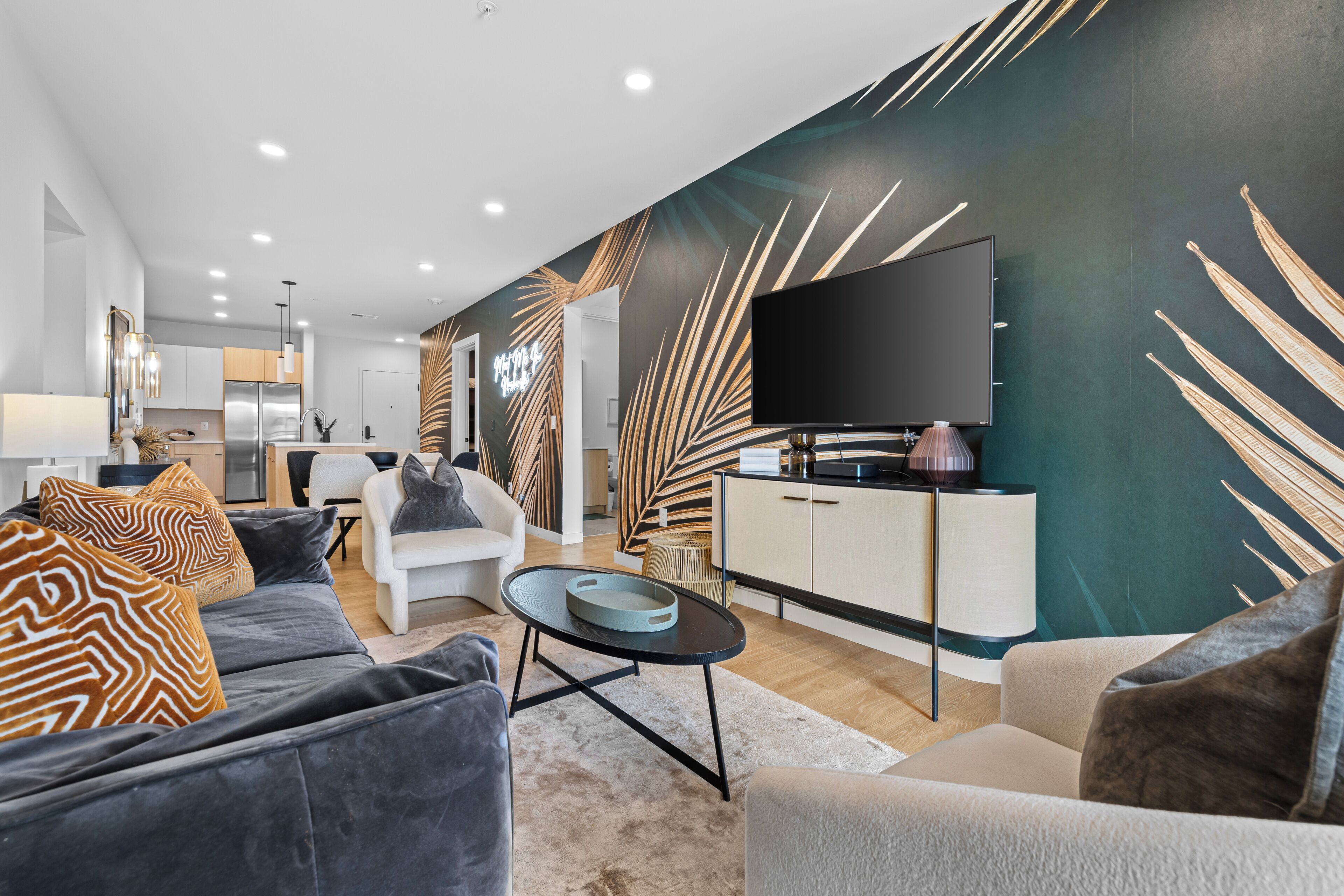 A modern living room with a sofa, armchair, and a flat-screen TV.