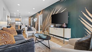 Una sala de estar moderna con un sofá, un sillón y un televisor de pantalla plana.