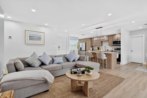 A modern living room with a grey sofa, a coffee table, and a kitchen in the background. - Tulum Vibes House.
Perfect for relaxation and entertaining. (Jupiter)