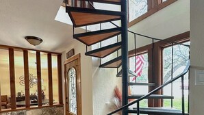 Un escalier en colimaçon avec des marches en bois, menant à un deuxième étage.