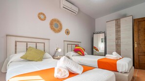 Une chambre d’hôtel avec deux lits, un climatiseur, un miroir et une armoire.