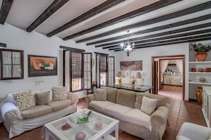 A living room with two sofas, a coffee table, and a chandelier.