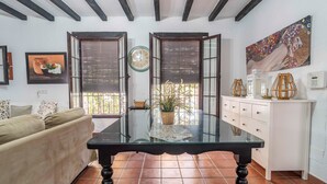 A room with a sofa, a table with a plant, a clock, and a painting on the wall. - Rural House 'Carula' with Private Pool, Wi-Fi and Air Conditioning (La Puebla de Cazalla)