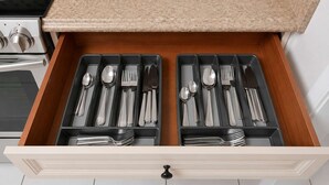 A kitchen drawer with utensils and cookware.