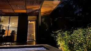 En moderne bygning med to etager, en balkon, en pool og en have.