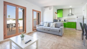 A modern apartment with a living room, kitchen, and balcony.