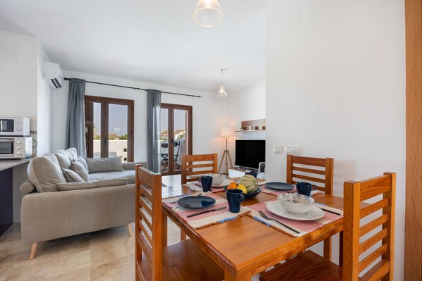 A dining area with a wooden table, chairs, and a sofa.