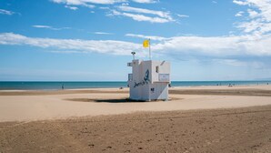 A lifeguard tower on a beach with clear skies and calm waters. - Apartment 'Les Balcons De La Méditerranée' with Sea View and Balcony (Narbonne-Plage)