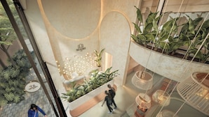 A hotel lobby with a reception desk, seating area, and multiple potted plants. - Hotel Tres Altares Sabaneta (Sabaneta)