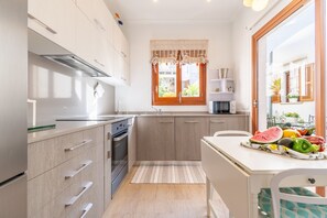 Une cuisine moderne avec une fenêtre, un coin repas avec une table et une vue sur l’extérieur.