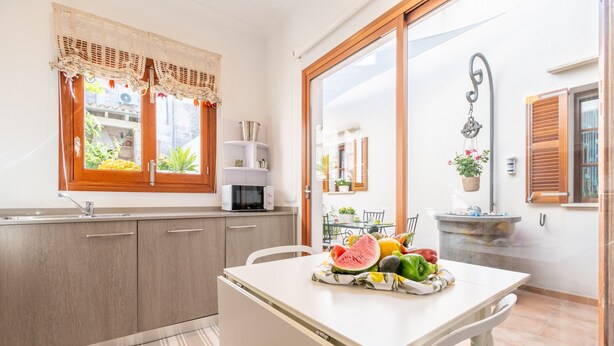A kitchen with a white table, a sink, and cabinets. - Holiday Home 'Son Amanada' with courtyard and Wi-Fi (Santa Margalida)