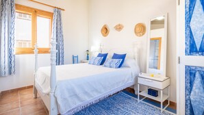 A bedroom with a four-poster bed, a bedside table, a mirror, and a window with curtains. - Holiday Home 'Son Amanada' with courtyard and Wi-Fi (Santa Margalida)