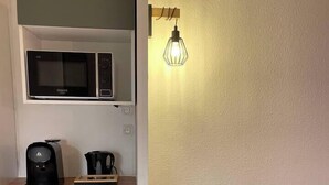 A compact kitchenette with a microwave, coffee maker, and mini-fridge.