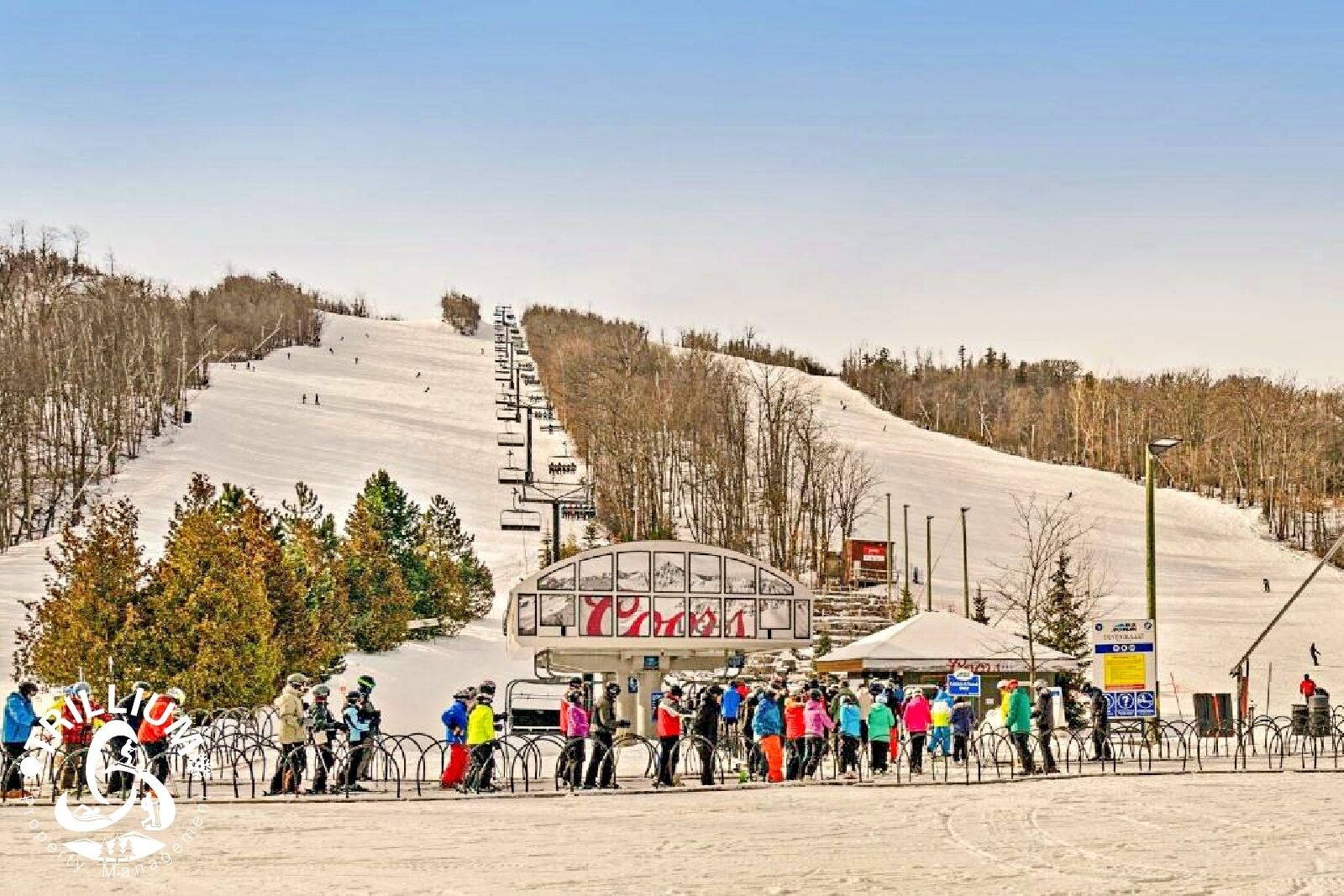 A ski resort with a chairlift, a sign reading "RILLION," and a crowd of people at the bottom of the slope.