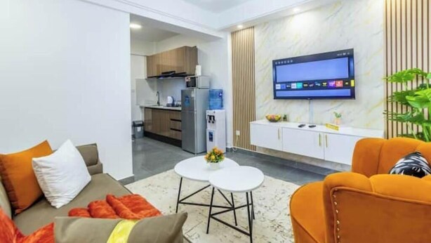 A modern living room with a sofa, a coffee table, and a TV mounted on the wall.