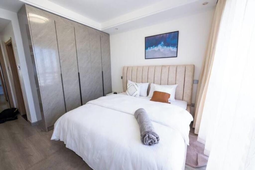 Une chambre d’hôtel avec un grand lit, une armoire et un tableau au mur.