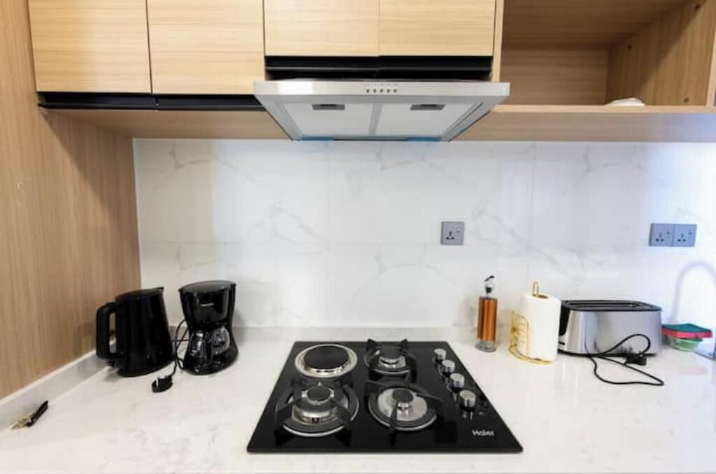 Una cocina con estufa a gas, cafetera y tostadora.