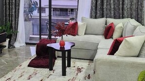 Una sala de estar con un sofá, una mesita y un florero.