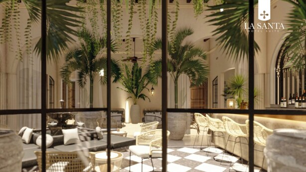 A hotel suite with a checkered floor, wicker furniture, and hanging plants. - La Santa Hotel Boutique (Santa Marta)