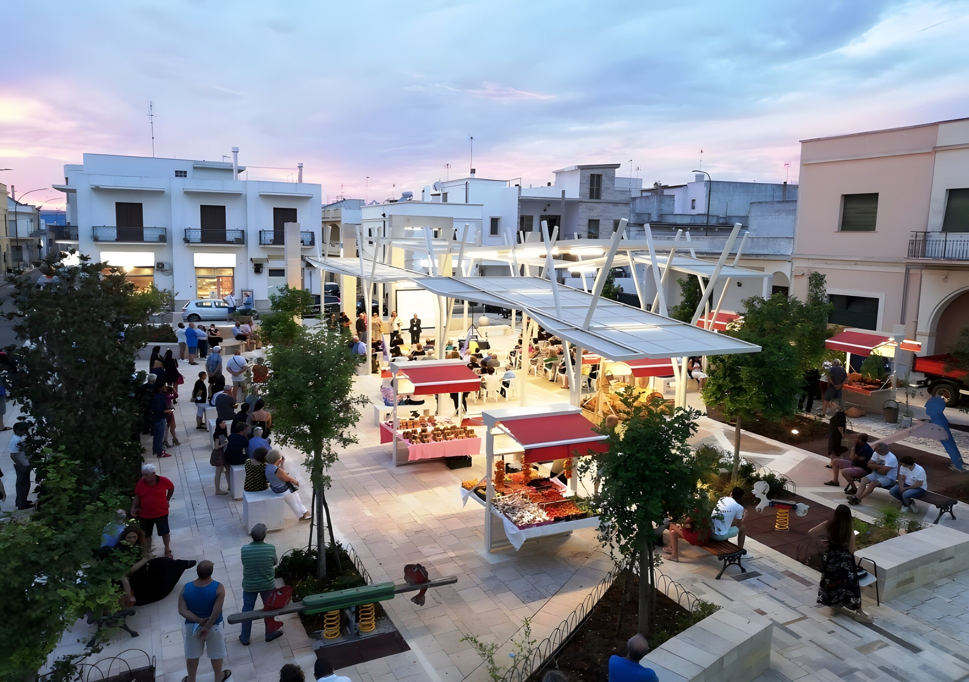 An outdoor market with various stalls and people.