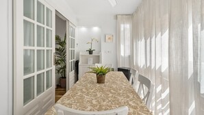 A hallway with a dining table, chairs, a ceiling fan, and a potted plant. - Apartment 'Fuengirola Beach' with Sea View, Wi-Fi and Air Conditioning (FUENGIROLA)