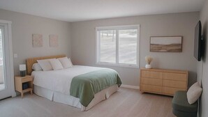A bedroom with a bed, bedside tables, a dresser, and a chair.