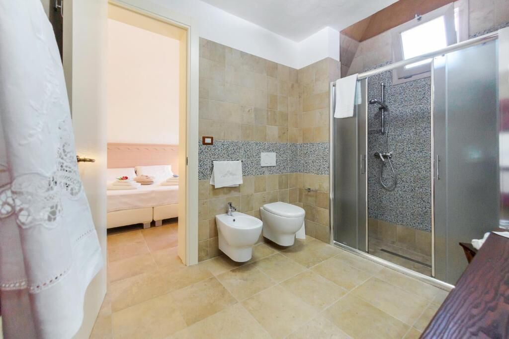 A bathroom with a shower, bidet, and toilet.