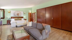 Un dormitorio con cama, mesita de noche, lámpara y un armario grande.