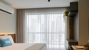 Una habitación de hotel moderna con cama, escritorio y zona de comedor.